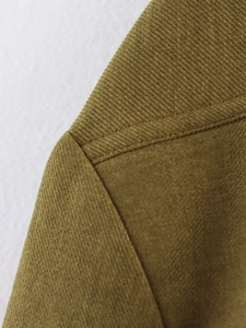 Detail of shoulder seam and olive green corduroy fabric texture on bomber jacket set