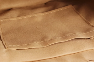 Close-up of the internal compartment and pocket of the woven tote bag in brown canvas