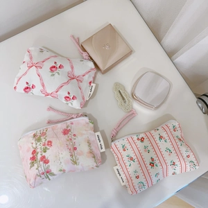 Detailed flat lay of pink floral cotton pouches with rose patterns and zip closure