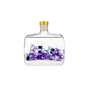 Preserved flower reed diffuser in square glass bottle with gold cap and purple botanicals
