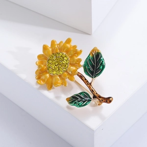 Detailed view of sunflower brooch with yellow enamel petals and rhinestone center