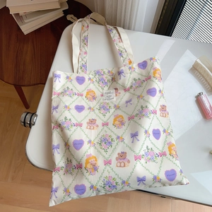 Vue détaillée de dessus d'un sac cabas en coton beige avec motifs floraux et logo