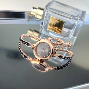 Detail of rose gold snake-style watch strap with black enamel and quartz dial