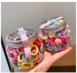 Close-up of colorful high-elastic hair ties in transparent jars with silver metal lids