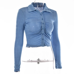 Detail of blue long sleeve crop top with lapel collar and ruched chest design