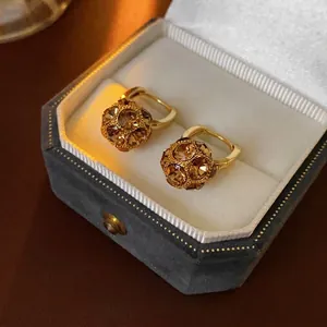 Gold plated hoop earrings with amber crystal sphere drops in a velvet jewelry box