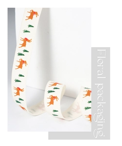 Close-up of Christmas ribbon with reindeer and tree patterns on a white gift box