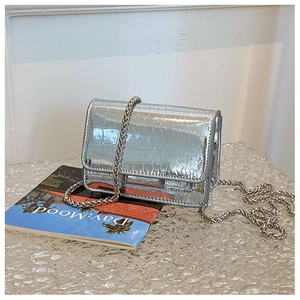 Detail of silver crocodile-patterned mini square bag with metallic chain strap