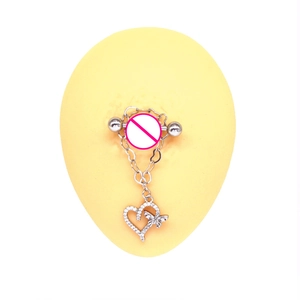 Macro shot of silver heart and butterfly charm nipple ring on silicone model