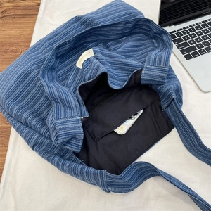 Interior view of blue corduroy tote bag showing spacious lining and zipper pocket