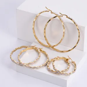 Set of three sizes gold wavy stainless steel hoop earrings with white rhinestones
