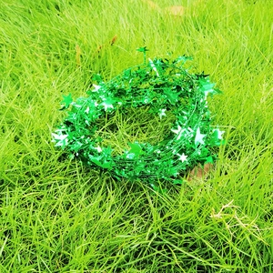 Detail view of green star-shaped tinsel garland for Christmas decoration on grass
