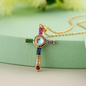 Minimalist 18K gold plated cross necklace with colorful zircon stones on green stand
