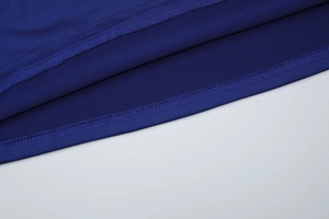 Détail de la couture à double aiguille sur l'ourlet d'une robe bleue en dentelle française