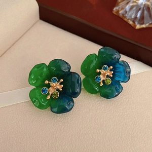 Détail de boucles d'oreilles vintage en résine dégradé vert avec centre doré