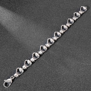 Detailed view of hip hop boxing glove charms on a silver stainless steel men's bracelet