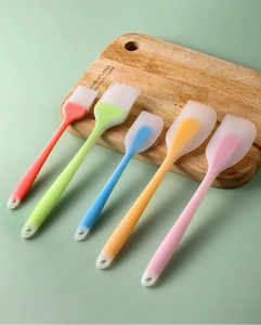 Detailed view of 5-piece colorful silicone spatulas and brushes on a wooden board