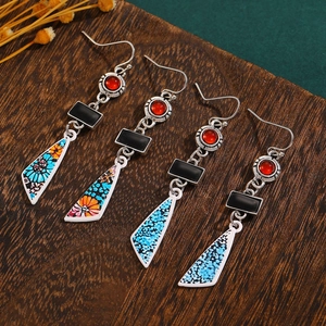 Detail of vintage bohemian flower earrings with turquoise beads on dark wood background