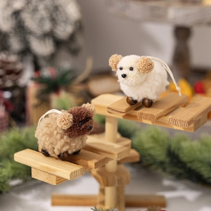 Close-up of handmade plush lamb ornaments with wooden bead legs on a festive wooden stand