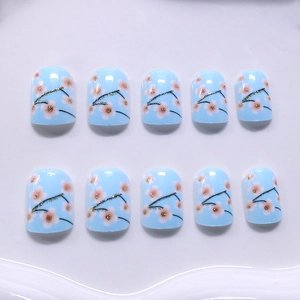 Short square light blue press-on nails with pink cherry blossoms and gold glitter accents