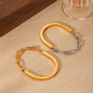 Détail de bracelets à maillons en U or et argent sur un fond de tissu texturé élégant