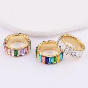 Macro detail of gold plated rings featuring colorful baguette cut cubic zirconia crystals