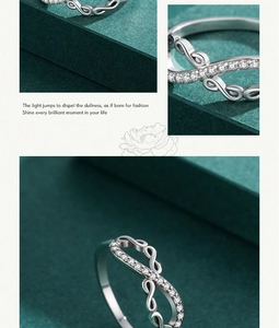 Detail of S925 sterling silver infinity ring with inlaid diamonds on a green background