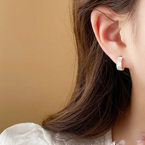 Close-up of star-shaped earrings with zircon crystals on model for elegant styling