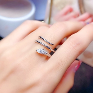 Macro detail of silver snake ring with pear-cut stone and intricate coiled scale texture