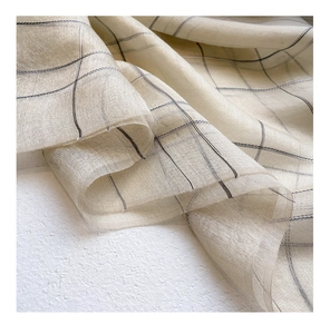 Detailed close-up of beige plaid silk wool scarf fabric showing soft drape and texture