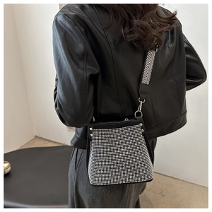 Détail du sac seau en strass argentés avec base en cuir noir et bandoulière chevron