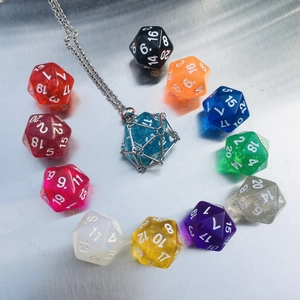 Macro shot of D20 dice pendant in silver mesh net with various colorful resin options