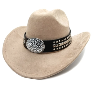 Detail of khaki suede cowboy hat featuring a large rhinestone buckle and metal studs