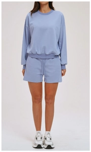 Light blue sweatshirt and drawstring shorts set shown on model in studio setting
