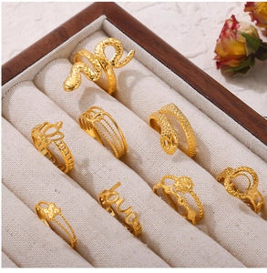 Detailed view of eight assorted gold-plated titanium steel rings in a velvet jewelry box
