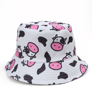 Detail of white bucket hat with pink cartoon cow pattern and black spots