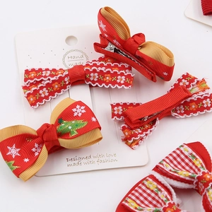 Festive red and gold Christmas bow hair clips with snowflake and tree patterns