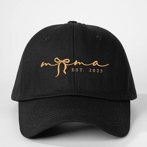 Detailed view of the gold MAMA EST. 2025 embroidery on a black cotton baseball cap