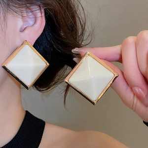 Boucles d'oreilles vintage en résine losange avec bord doré et design géométrique blanc