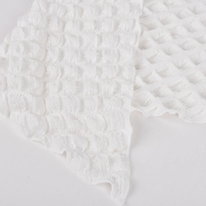 Close-up of white bubble textured fabric with honeycomb pleated pattern detail