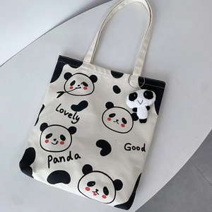 Detail der Panda-Stofftasche mit Plüsch-Panda-Anhänger auf minimalistischem Hintergrund