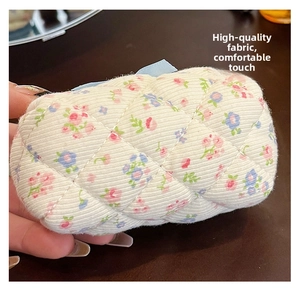 Close-up of mini quilted cotton makeup bag with floral pattern and soft texture