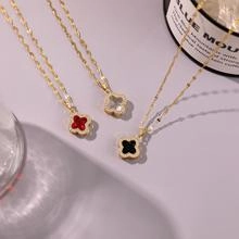 Detail of four-leaf clover pendant necklaces in red, white and black colors