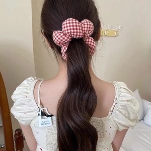 Floral sponge scrunchie with red and white plaid pattern on women's bun hairstyle