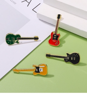 Set of four colorful electric guitar enamel pins in red, black, green and orange tones