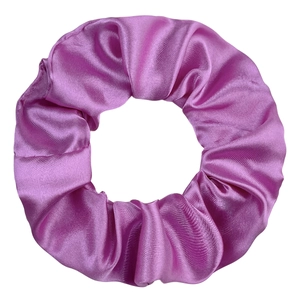 Detailed view of magenta satin scrunchie with glossy texture and elegant folds