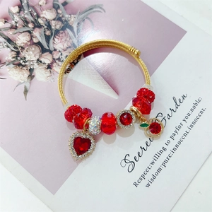 Elegant gold titanium steel cuff bracelet with red crystals and cherry heart pendants