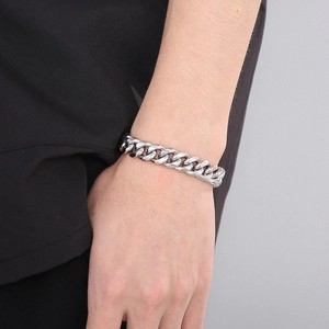 Detailed close-up of a silver Cuban link bracelet worn on wrist for a modern street style