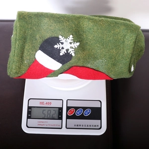 Chaussette de Noël LED verte avec flocons de neige pesée sur une balance électronique