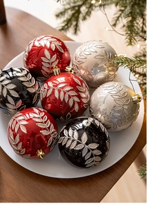 Dettaglio macro di palline di Natale rosse e oro con motivi a foglia d'argento